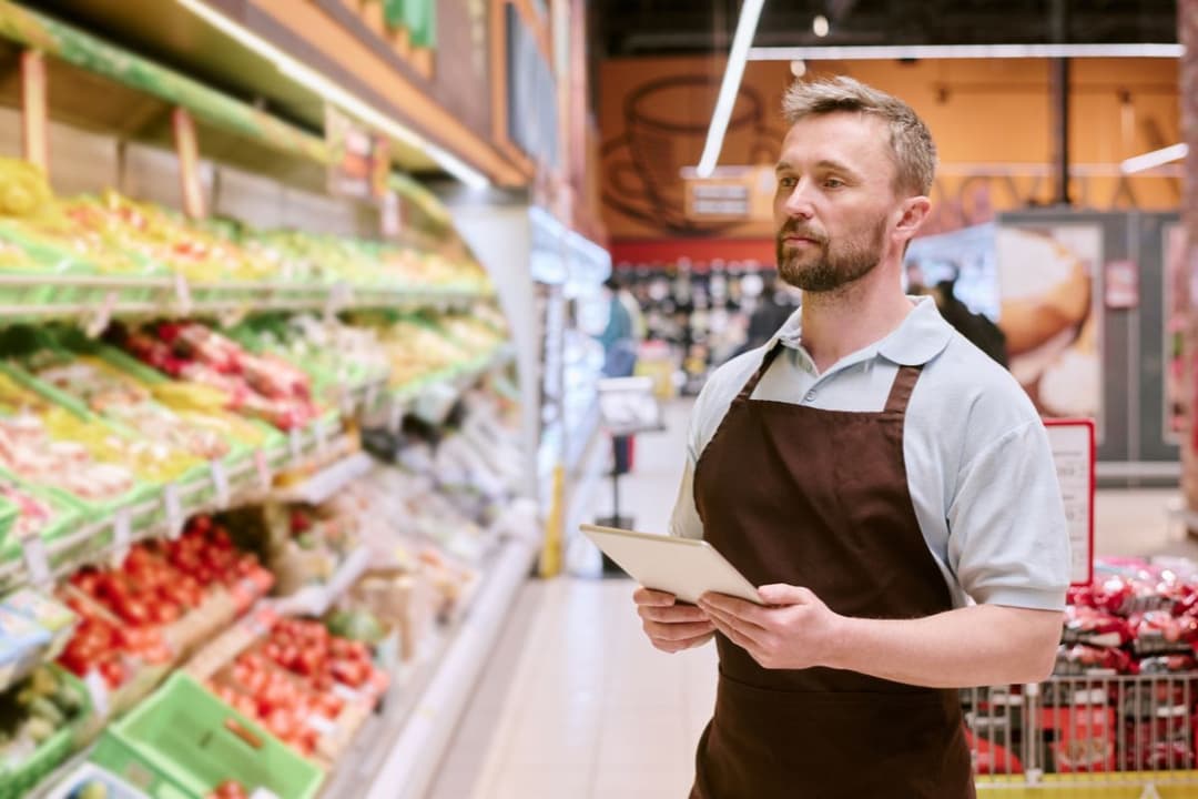 Grocery Store Employee Using Tablet for Inventory Management