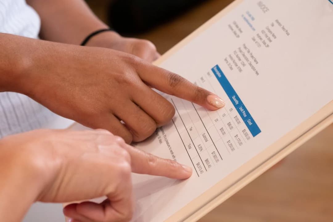 Persons Pointing at the Numbers on the Invoice