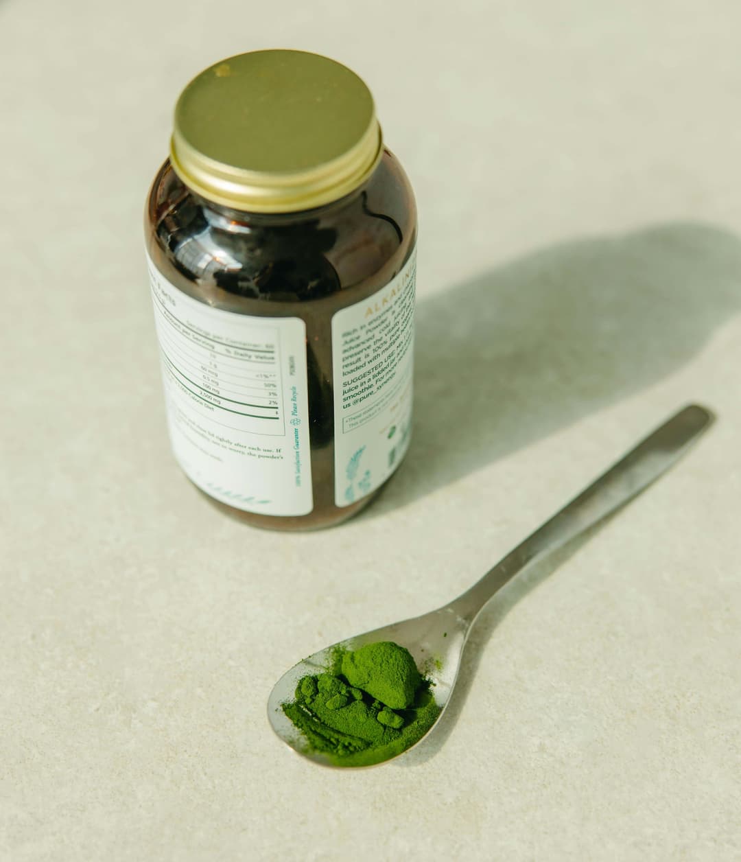 White Labeled Bottle Beside Silver Spoon